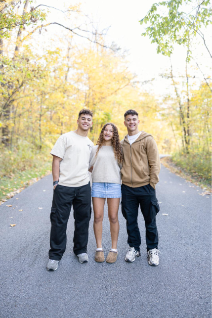 girl poses with young men on road